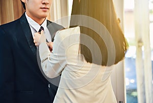 A male businessman is dressed up with the help of his wife.