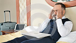 Male businessman finishing working closing using laptop having headache at business trip
