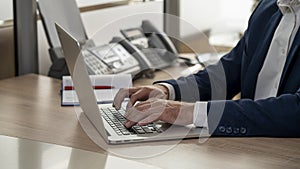 Male businessman typing on a laptop, close-up, selective focus.Concept: working in a modern office, concluding contracts and trans