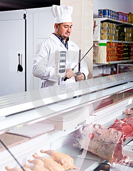 Male butcher in kosher section at supermarket