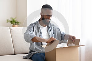 Male buyer unpack cardboard box at home