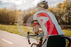 Male bycyclist in sportswear, cycling on bike path