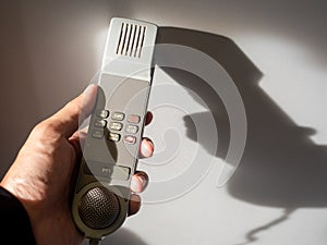 Male cabin crew holding interphone in aircraft cabin.