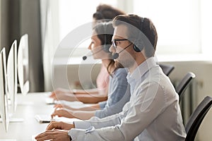 Male call center agent in wireless headset consulting online client