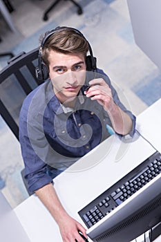 Male call centre operator doing his job top view