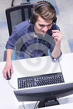 Male call centre operator doing his job top view