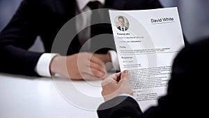 Male candidate presenting CV to HR manager at job interview, first impression photo