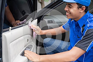 Male car cleaning service worker washing black car