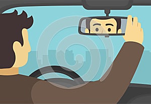 Male car driver adjusting rear view mirror in a car. Close-up back view of a driver checking rear mirror.