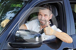 Male car driver making thumbs up gesture