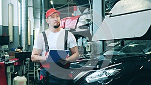 Male car mechanic taking notes at an auto repair shop