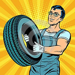 Male car mechanic with wheel