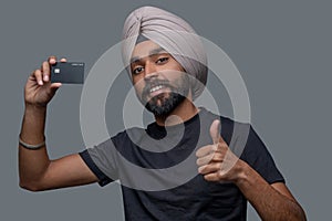 Male cardholder in the turban approving his payment system