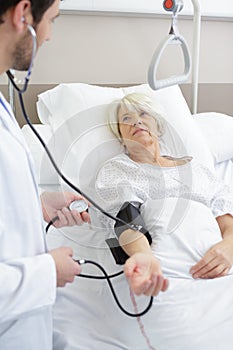 male caregiver checking blood pressure to senior woman