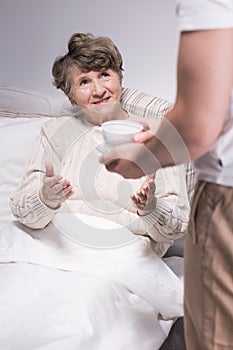 Male carer assisting senior woman