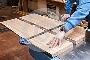 Male carpenter glues two boards in a carpentry workshop. Dowel and adhesive connection. Manufacture of furniture boards and counte