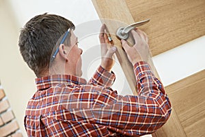 Male carpenter at lock installation