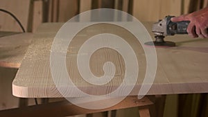 Male carpenter polishing wood in workshop.