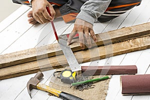 Male carpenter working with wood pencil and tools at work place. Background craftsman tool