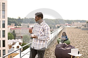 Male in casual shirt, with fork in hand and vegetable salad in bowl.