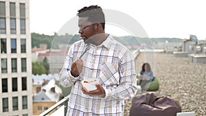 Male in casual shirt, with fork in hand and vegetable salad in bowl.