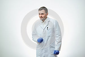 A male caucasian doctor in a white lab coat and blue disposable medical gloves