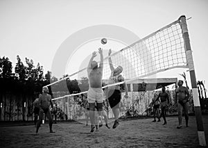 male Caucasians, Arabs, Africans playing volleyball on the beach