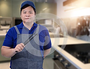 Male Chef assistant holding Kitchen equipment