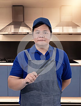 Male Chef assistant holding Kitchen equipment