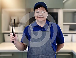 Male Chef assistant holding Kitchen equipment