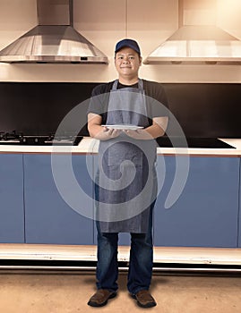 Male Chef assistant holding White plate