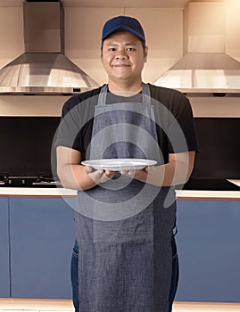 Male Chef assistant holding White plate