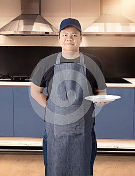 Male Chef assistant holding White plate