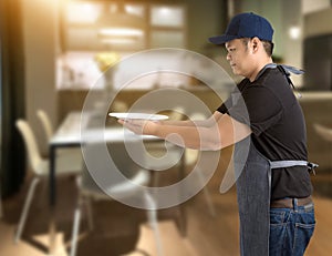 Male Chef assistant holding White plate