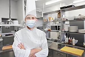 Male chef cook in face mask at restaurant kitchen