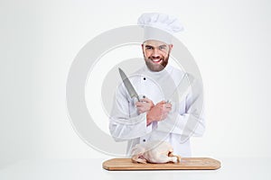 Male chef cook standing with knifes and chicke