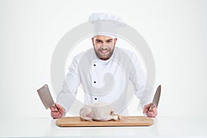 Male chef cook standing with knifes and chicken