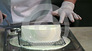 Male chef covering a cake with mirror icing