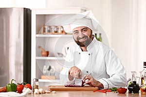 Male chef cutting onion in kitchen