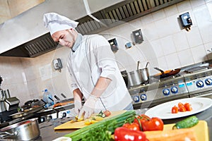 Male chef cutting vegetables for salad food