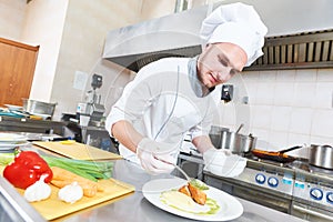 Male chef decorating food plate