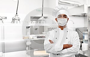 Male chef in face mask at restaurant kitchen