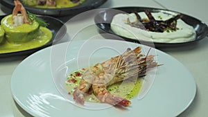 Male chef garnishing shrimp dish at the kitchen