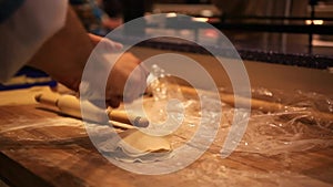 Male chef hands preparing dough with rolling pin