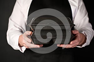 Male Chef holding lunch box with food in hand, black background