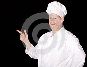 Male chef pointing on black background