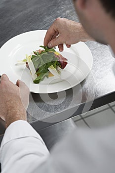 Male Chef Preparing Salad In Kitchen