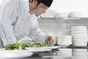 Male Chef Preparing Salad In Kitchen