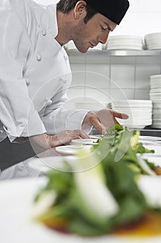 Male Chef Preparing Salad In Kitchen