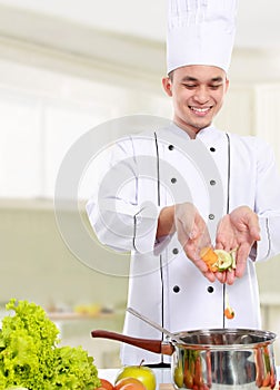 Male chef put some ingredient in the pan